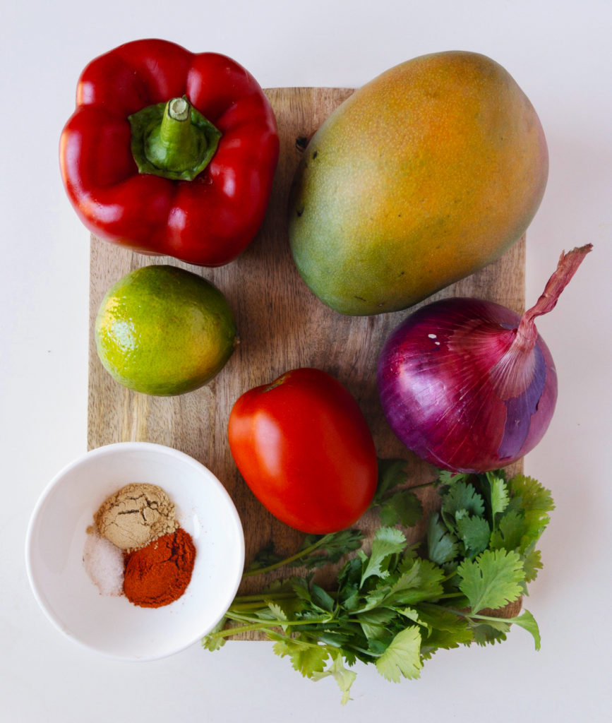 Ingredients for the Mango Chili Salsa recipe — red bell pepper, mango, lime, tomato, red onion, cilantro, ginger powder, chili powder, salt. 