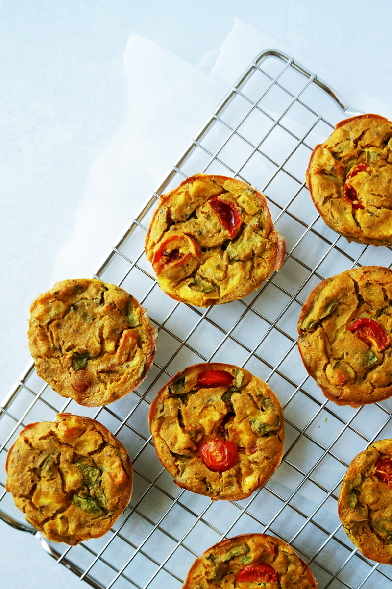 High-protein mini vegan frittatas  (egg muffins) made of chickpea flour and tofu on a cooling rack. 
