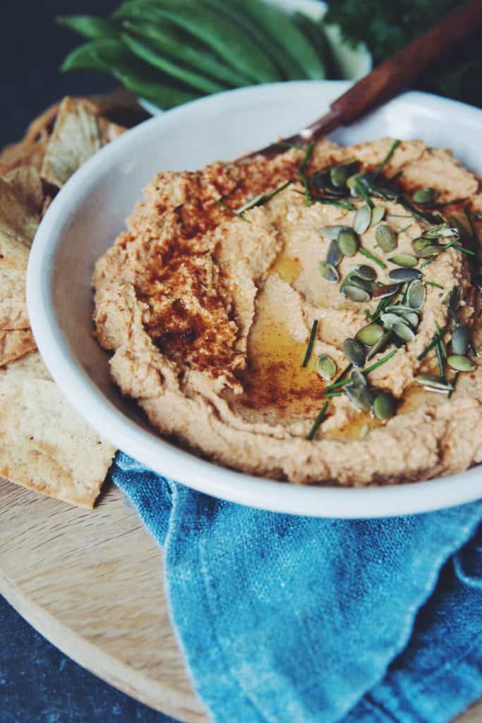 A great vegan pantry recipe – pumpkin hummus in a bowl topped with pumpkin seeds. 
