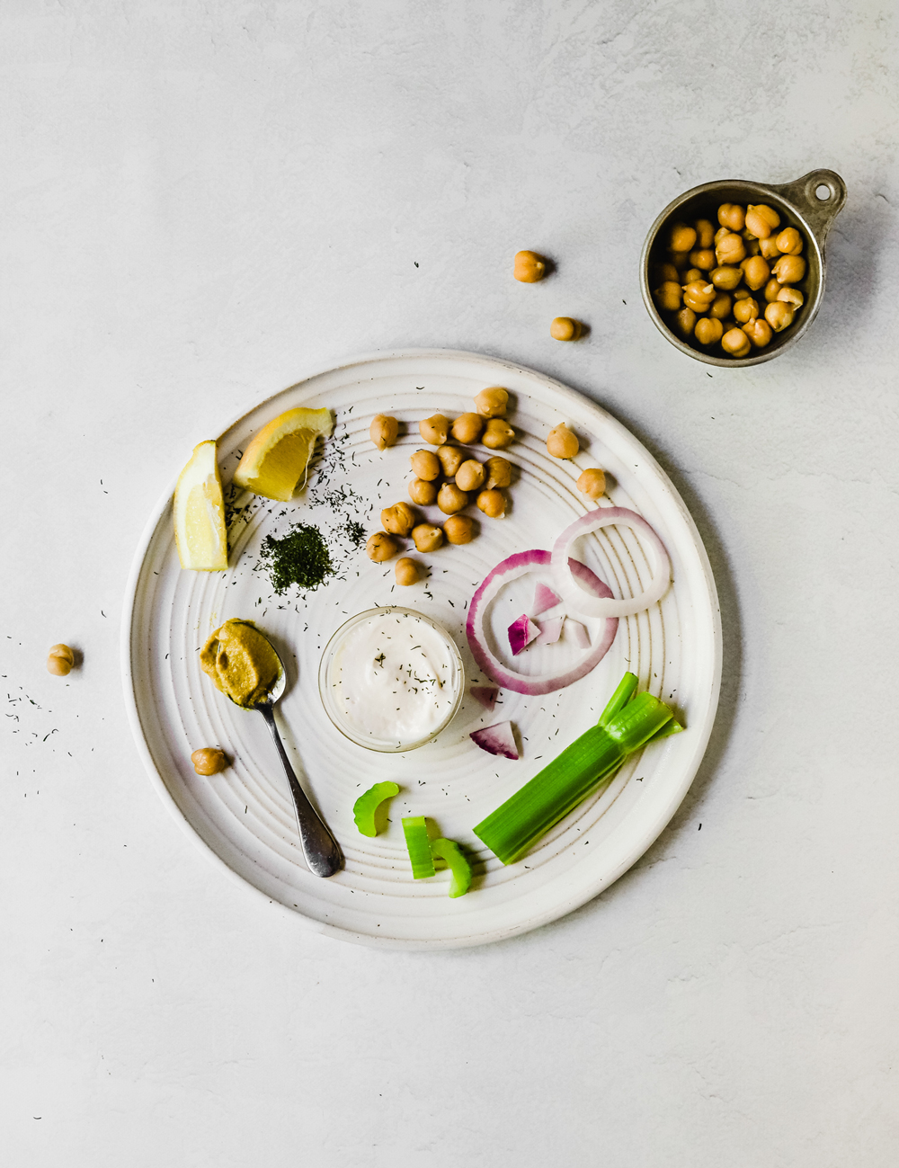 Ingredients for chickpea salad on a large white plate.