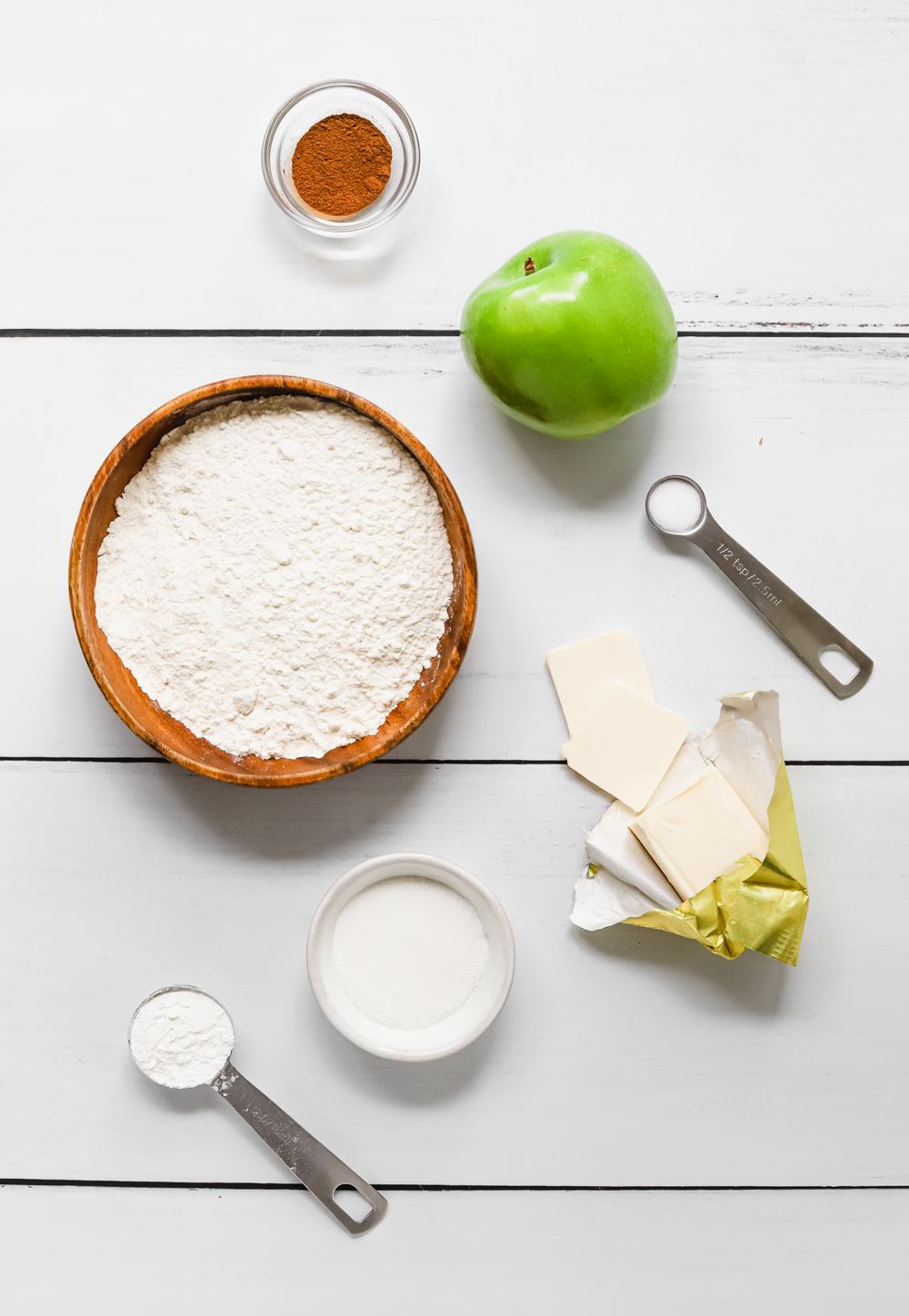 Ingredients to make a vegan apple galette: granny smith apples, cinnamon, salt, sugar, cornstarch, butter, and all purpose flour.