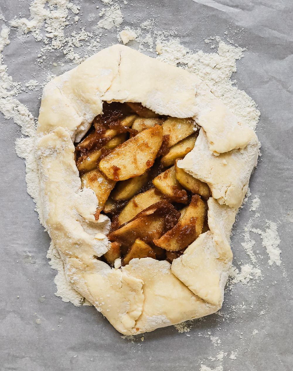 Unbaked galette on a floured piece of parchment paper.