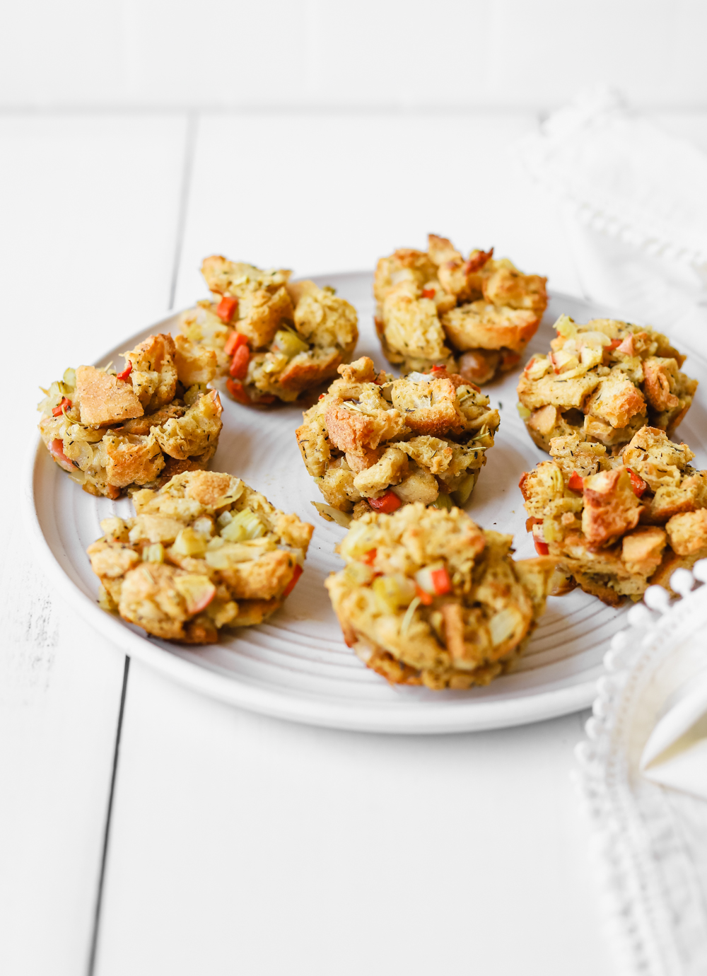 Homemade vegan stuffing muffins on a large white plate.