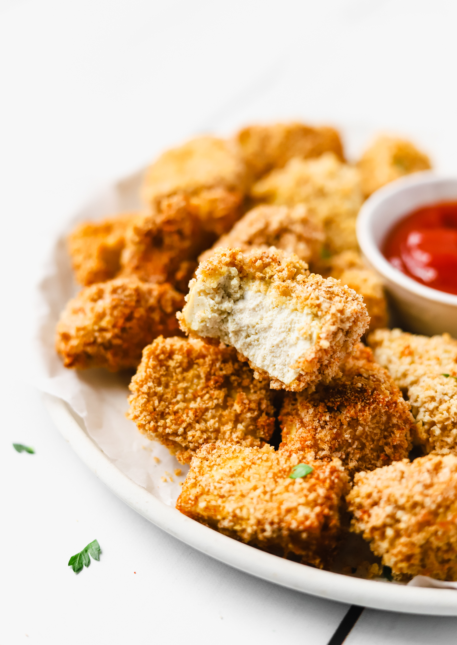 Baked vegan tofu chicken nuggets on a plate.