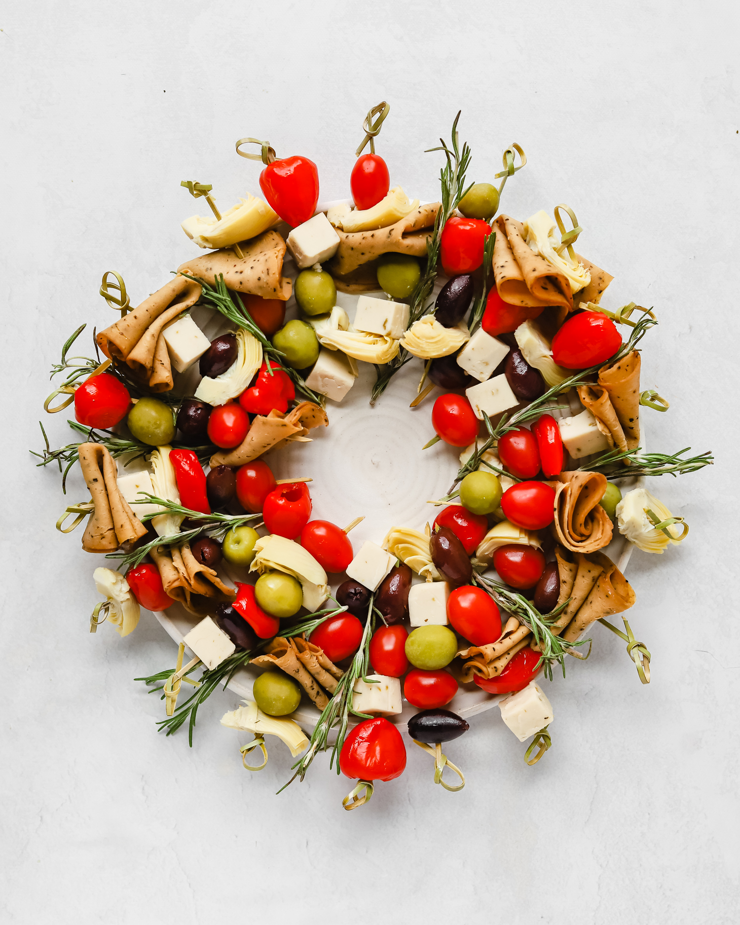Vegan charcuterie Christmas wreath snack board on a large white serving plate.
