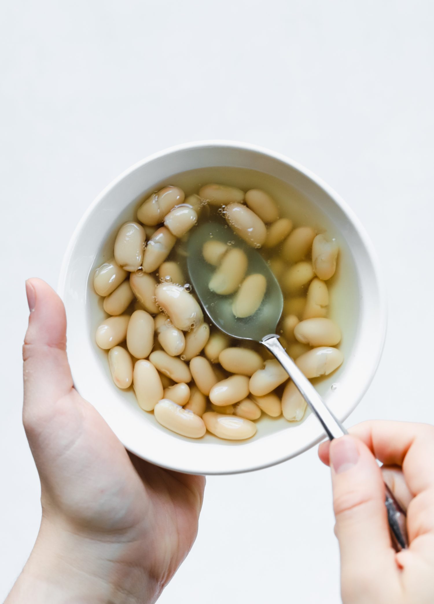 Cannellini beans in aquafaba a small white bowl